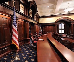 A gavel striking a block in a courtroom, symbolizing a legal ruling.