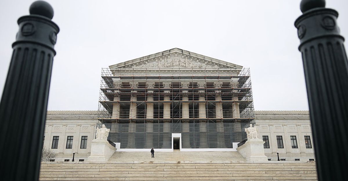 A gavel rests on a legal document with the Supreme Court building in the background.