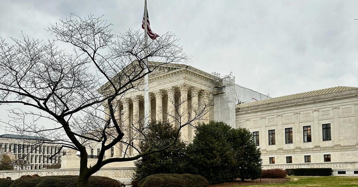 A close-up shot of the United States Supreme Court building's facade, with shadows emphasizing its imposing structure.