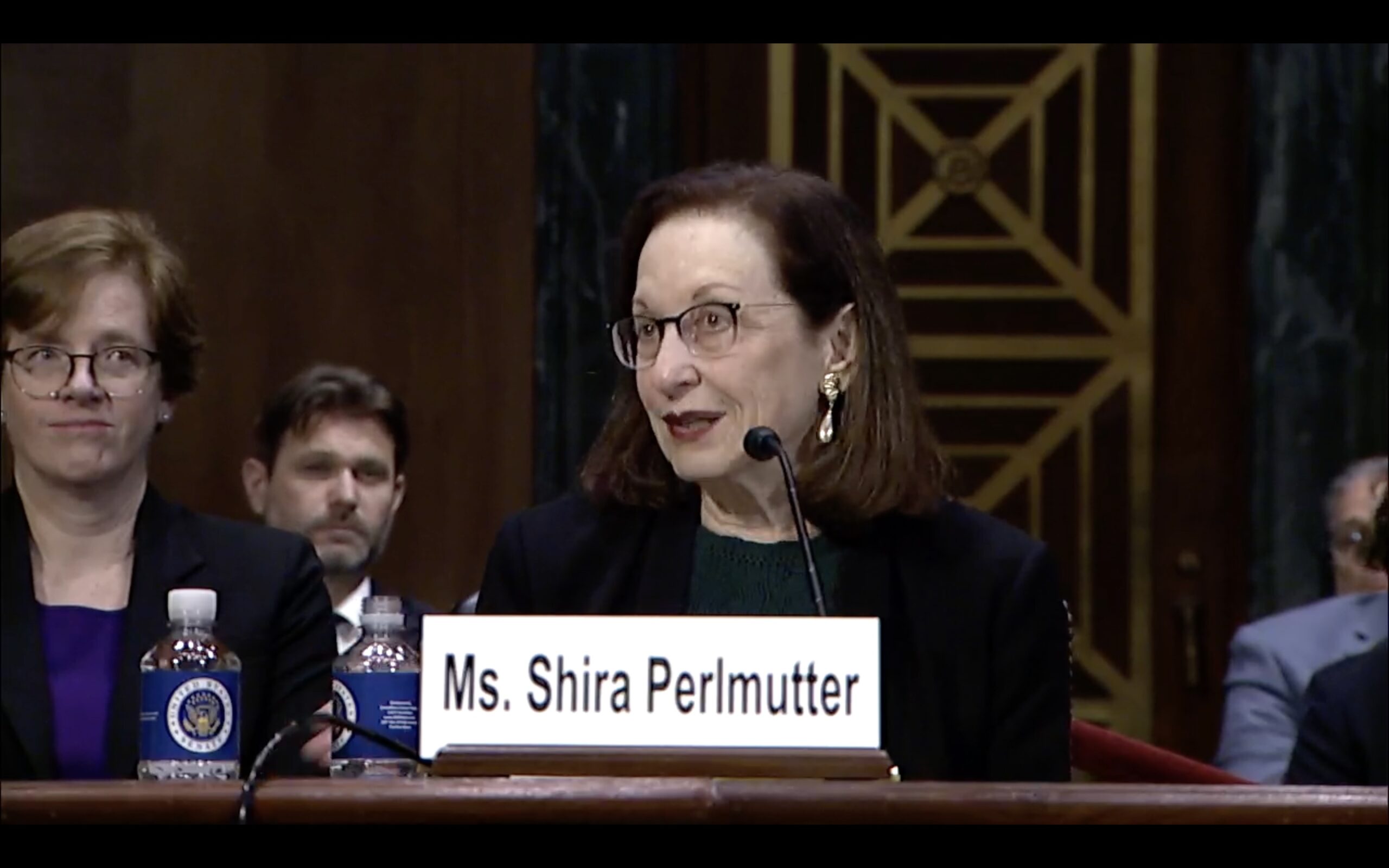 Senators in a hearing room, looking serious, with microphones on a table.