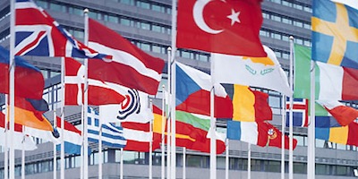 A gavel resting on a pile of legal documents with a circuit board faintly visible underneath.