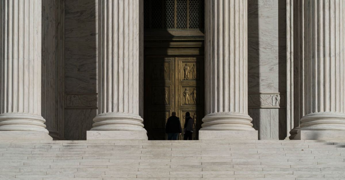 Supreme Court building exterior with a gavel on a desk