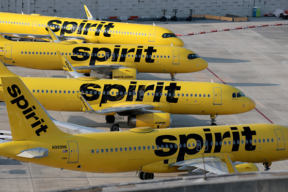A Spirit Airlines airplane parked at a gate, with its distinctive yellow livery.