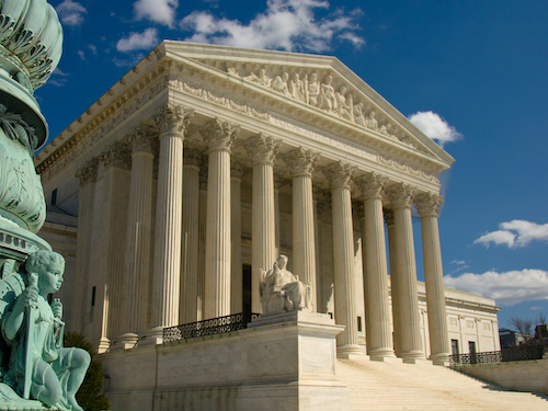 A gavel striking a sound block on top of legal documents.