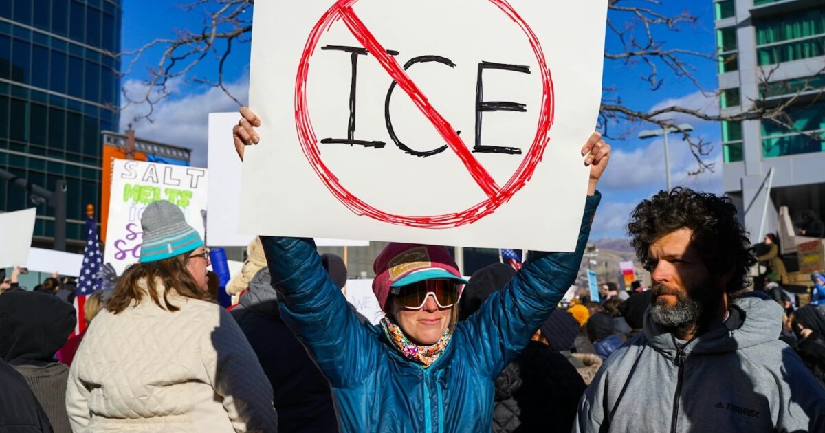 A group of diverse individuals holding signs at a protest.