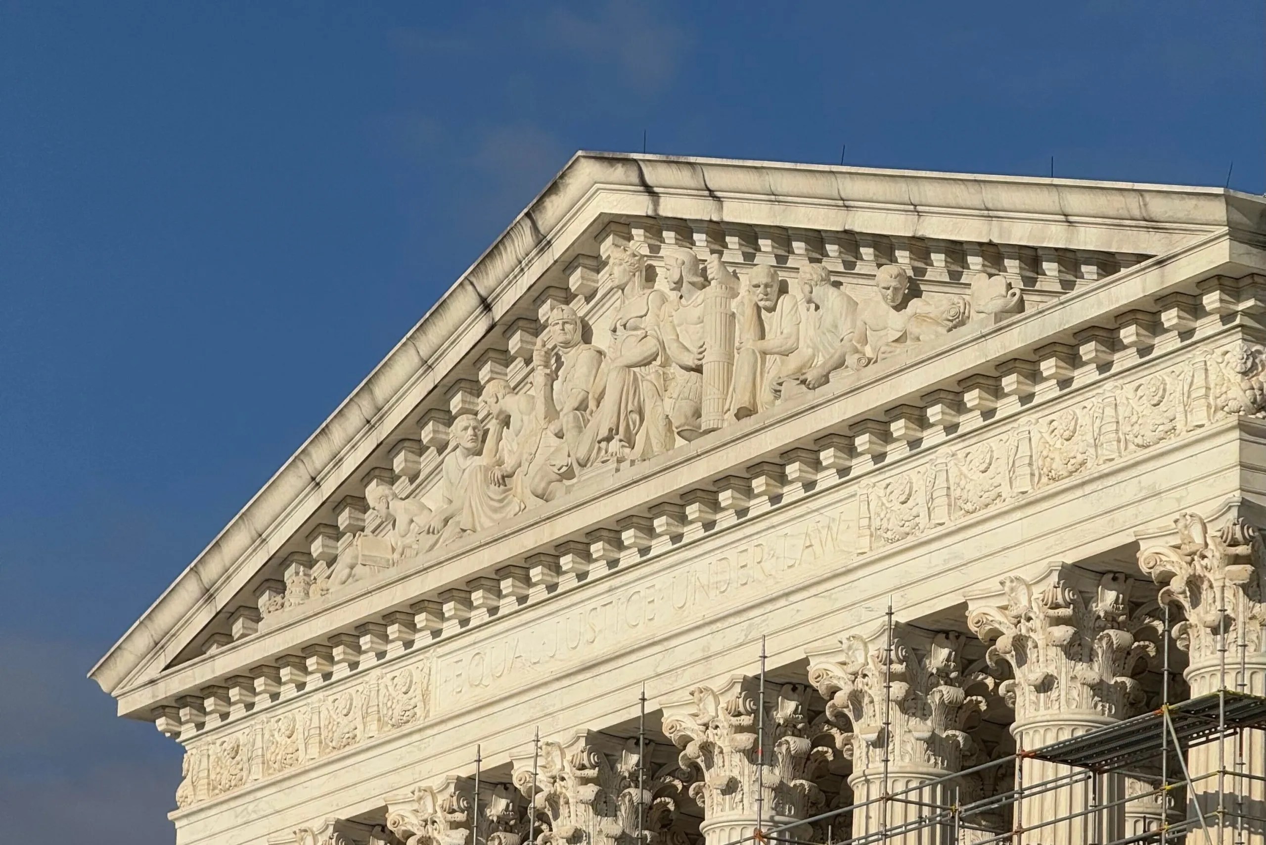 Chief Justice John Roberts speaking at podium with Smithsonian museums in background