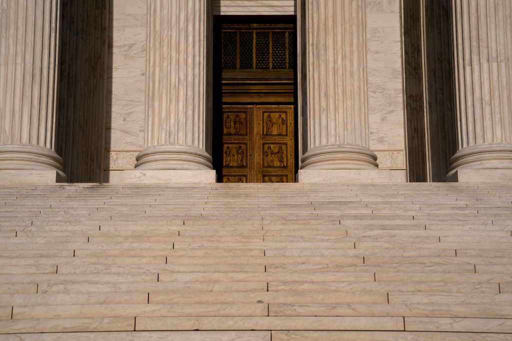 The exterior of the Supreme Court building with a gavel on a desk.