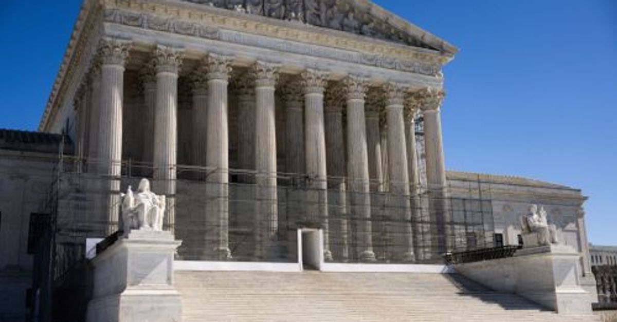 A gavel rests on a legal document with the Supreme Court building subtly blurred in the background.